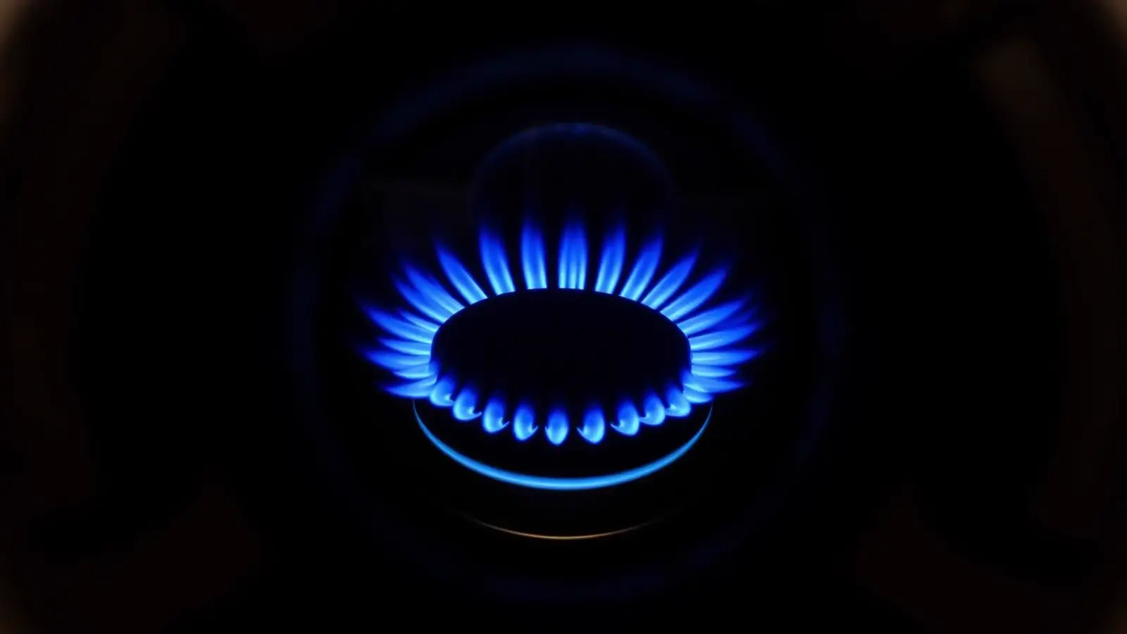Burner viewport on a gas water heater glowing while the appliance runs in a basement